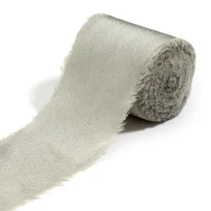 Dettaglio di nastro in raso grigio chiaro con bordi sfrangiati perfetto per confezioni regalo.