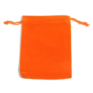Dettaglio sacchetto in velluto arancione con coulisse, primo piano custodia gioielli morbida.
