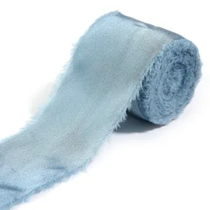 Primo piano dettagliato di nastro in raso azzurro sfilacciato, ideale per bouquet e confezioni regalo.