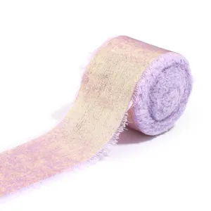 Detail shot of frayed edge gold foil velvet ribbon roll for gift wrapping and wedding decor.