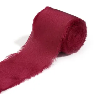 Dettaglio nastro in raso bordeaux sfrangiato, perfetto per confezioni regalo e fai da te.