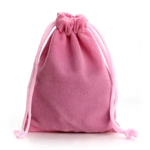 Dettaglio ravvicinato della borsa in morbido velluto rosa con coulisse per piccoli gioielli e trucchi.