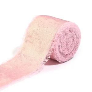 Exquisite pink metallic flocked ribbon roll with raw torn edges for elegant gift wrapping.