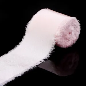 Primo piano dettagliato di un nastro in raso rosa chiaro sfilacciato per pacchi regalo fai da te