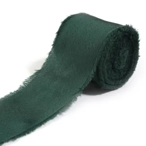 Primo piano di nastro in raso verde scuro con frange, morbida texture di tessuto in rotolo.