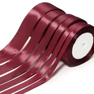 Dettaglio rotolo nastro di satin bordeaux primo piano texture liscia lucida per fai da te.