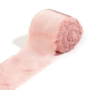 Primo piano dettagliato di nastro in raso rosa con frange per matrimoni e confezioni regalo.