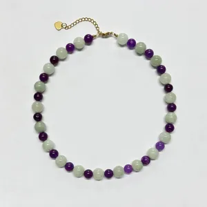 Primo piano della collana di perle tonde in pietra naturale colorata viola e verde.