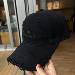 Gros plan sur les détails de la casquette de baseball noire usée avec broderie vintage.