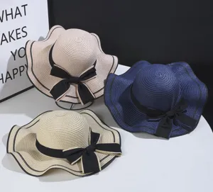 Women summer straw hat with wide wave brim and black bowknot, elegant sun protection beach hat.