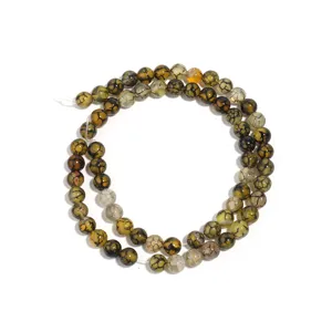 Detailed close-up shot of green cracked agate gemstone beads strand for DIY jewelry.