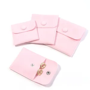 Detail view of pink velvet jewelry storage pouches with snap buttons for travel packs.