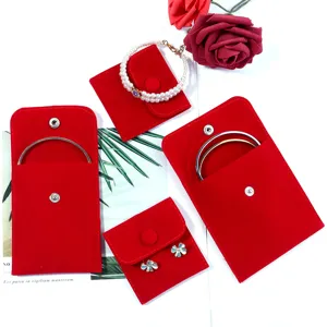Red velvet jewelry storage pouch detail view, snap button travel packaging bag for rings, necklaces.