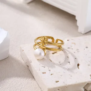 Nahaufnahme des goldenen Edelstahloffenrings mit Perlen und filigranem Stern Detail.