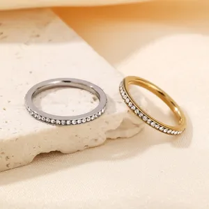 Closeup detail of minimal stackable pavé rings in gold and silver, delicate diamond band design.