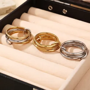 Close-up detail of multi-layer interlocking metal rings in a velvet jewelry box showcase.