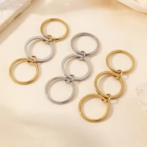 Close-up shot of trendy multi-layer stainless steel interlocking rings with sparkling crystal details.