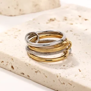 Detailed shot of multi-layer interlocking stainless steel stackable ring in gold and silver.