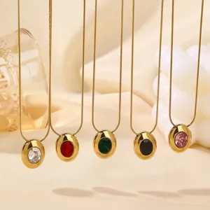 Detail view of colorful oval cubic zirconia pendant necklaces hanging on elegant fabric.
