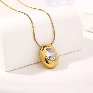 Detailed shot of gold-plated oval pendant necklace sparkling white cubic zirconia close up.