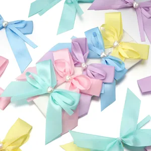 Primo piano dettagliato di fiocchi in nastro di raso colorato con perle a cuore per accessori.