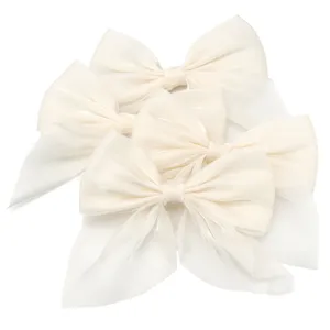 Close up view of elegant off white chiffon hair bows, delicate fabric texture details.