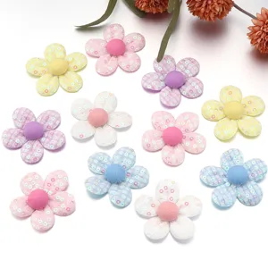 Vista di dettaglio ravvicinata di fiori in tessuto colorato con paillettes per accessori.