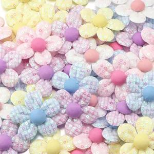 Dettaglio di accessori artigianali in tessuto con paillettes e quadri per fai da te.