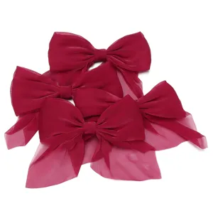 Chiffon bow hair clip accessory detail view, delicate sheer fabric design, vibrant red color.