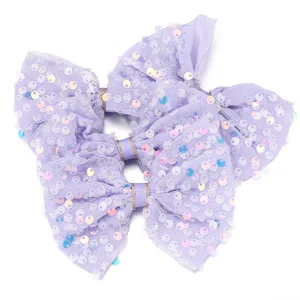 Primo piano dettaglio del fiocco in rete e paillettes viola chiaro, consistenza e lucentezza.