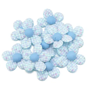 Dettagli di fiori in tessuto con paillettes a quadri blu, ideali per accessori fai da te.