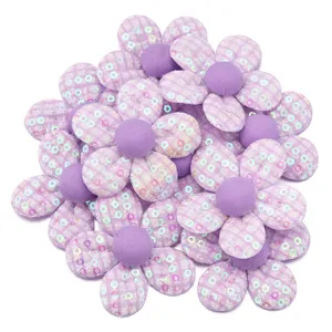 Primo piano dettaglio di fiore in tessuto a paillettes quadrate viola per decorazione fai da te.