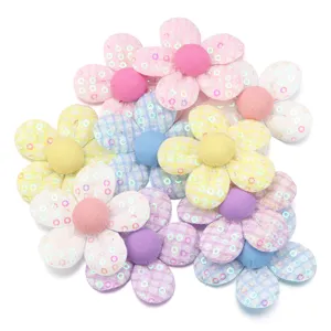 Dettagli di toppe di fiori in tessuto a quadri con paillettes colorate, ideali per forcine.