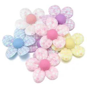 Primo piano di accessori floreali in tessuto paillettes, ideali per progetti fai da te.