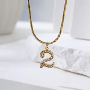 Gedetailleerde opname van de gouden slangketting met een prachtige strass cijfer hanger.