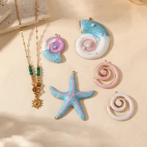 Vue détaillée de pendentifs étoile de mer et coquillage en acier avec collier de perles.