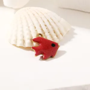 Dettaglio ciondolo pesce in smalto rosso con bordi metallici lucidi per creazione gioielli.