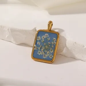 Handgemaakte hars hanger met geperste gedroogde witte bloemen in een prachtig gouden montuur detail.