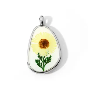 Gedetailleerd hars gedroogde bloem hanger met gele madeliefje in metalen rand voor ketting.