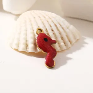 Primo piano del dettaglio del ciondolo smaltato cavalluccio marino rosso fai da te.