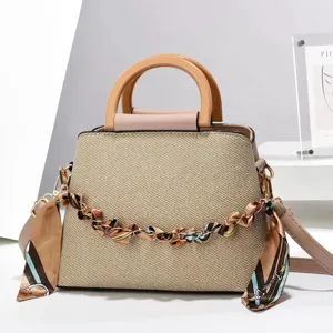 Élégant sac à main en paille avec poignée en bois, chaîne et bandoulière pratique.