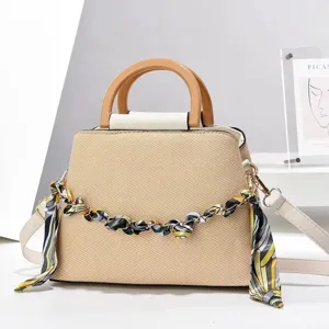 Élégant sac à main en paille avec poignée en bois et chaîne décorée pour la mode.