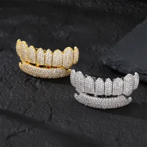 Close up detail of iced out hip hop grillz featuring gold and silver teeth with dazzling cubic zirconia.