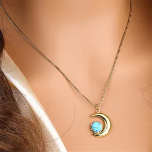 Gros plan d'un collier pendentif croissant de lune doré avec pierre turquoise pour femmes élégantes.