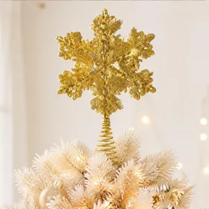 Gold glitter snowflake Christmas tree topper detail, sparkling holiday tree decor close up.