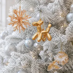 Primo piano dettagliato di un cagnolino di palloncino dorato e fiocco per albero di Natale.