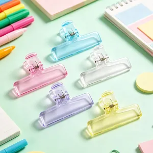 Close-up of colorful translucent plastic binder clips for office stationery and notes organization.