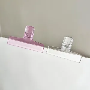 Detail view of wide mouth translucent plastic binder clips with metal spring in dual colors.