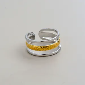 Detailaufnahme, die den filigranen mehrschichtigen Gold- und Silber-Offenen Ring zeigt.