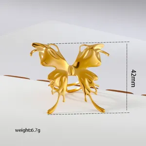 Gold metal butterfly ring detail, exaggerated abstract design, chic vintage finger jewelry closeup.